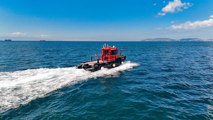 Plast Boat dynamic HDPE firefighting boat with an advanced tactical fire suppression system, navigating rough coastal waters with significant wake and high visibility features.